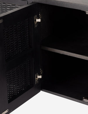 Open door of the Isaura black cane-paneled media console.
