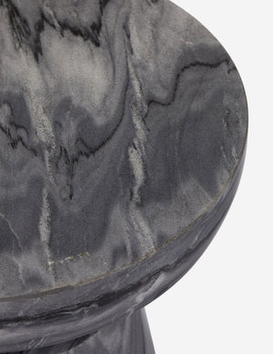 Close up view of the Zeller round carved ebony marble side table.