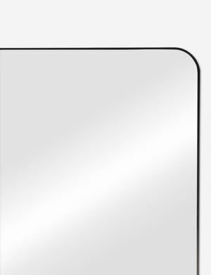 Close up corner view of the Aire rounded corner leaning floor mirror with black frame