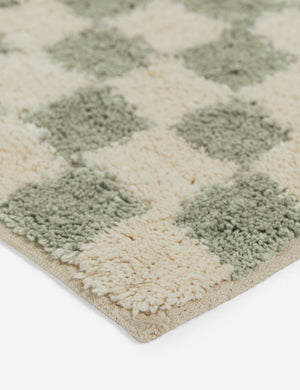 Close up corner view of the Two-tone checkerboard bath mat by Sarah Sherman in lichen green