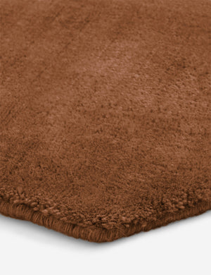 Close up of the corner of the Damara solid viscose rug in rose.