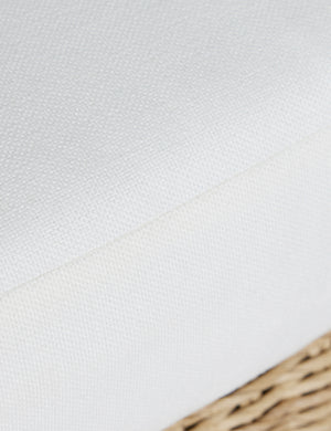 Close up of the seat cushion of the Hadler modern sculptural open frame wicker outdoor accent chair.