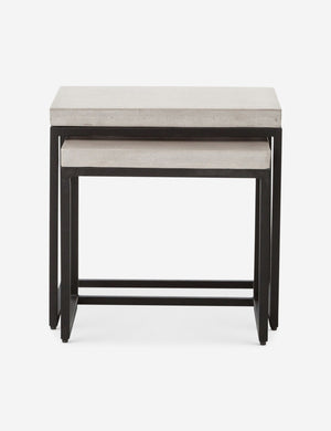 The Kallia indoor and outdoor nesting side tables with iron bases and concrete tops with the smaller table half nested into the bigger table