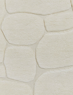 Close up view of the Kivi raised cobblestone pattern fringe wool area rug