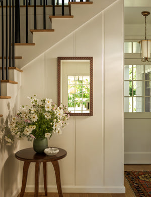 Campden matte green ceramic vase by Heidi Caillier styled on a round side table in an entryway.
