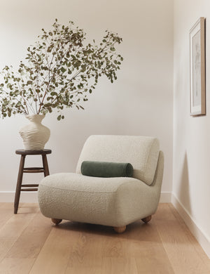 Kya textural boucle armless accent chair styled with a velvet bolster throw pillow.