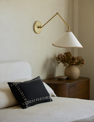 Accord Black Linen Lumbar Pillow by Elan Byrd styled on a bed.