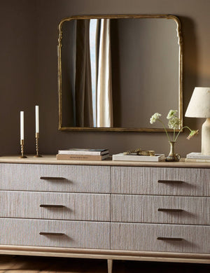 Coudray serpentine gold leaf frame mantel mirror hung above a dresser