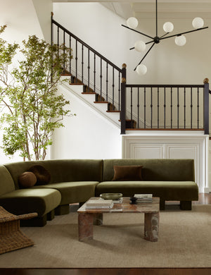  Cato solid marble square coffee table in orange marble and curved green velvet sectional sofa in a living room