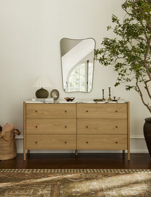 Belvoir thin brass framed wall mirror hanging above a dresser