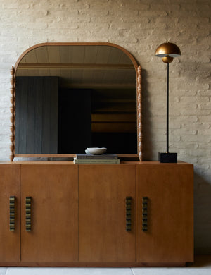 Topia arched carved wood mantel mirror by Ginny Macdonald in natural styled on top of a console table.