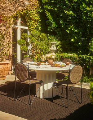 Shere handwoven striped outdoor rug by Sarah Sherman Samuel in Brown styled with an outdoor dining set.