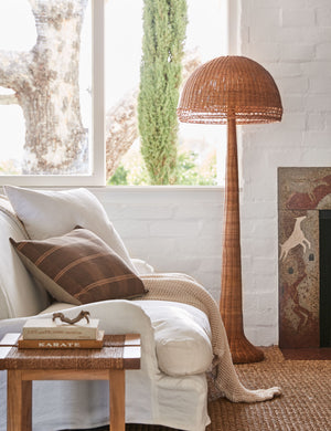 Quinley rattan coastal floor lamp styled next to a white slipcover sofa.