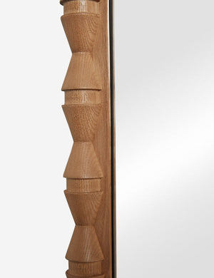 Close up of the frame details of the Topia arched carved wood mantel mirror by Ginny Macdonald in natural.