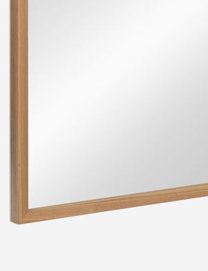 Bottom corner of the Paisley arched light wood framed floor mirror.