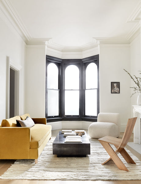 #color::natural-and-black #size::14--x-40- #insert::down #insert::polyester | The Peregrine black and white marled striped lumbar pillow lays in a living room with a yellow velvet sofa, floor to ceiling windows, and a wooden accent chair