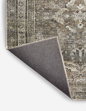 Corner shot of the Amalia distressed traditional rug folded over itself