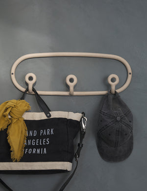 Cream speckled Trio Stoneware Coat Rack by SIN Ceramics with a bag and hat hanging from it