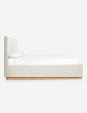 A side view of the Lockwood natural velvet-upholstered bed with a white oak base.