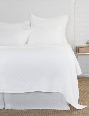 Ojai Cotton Matelasse white Euro Sham by Pom Pom at Home sits on a white framed bed with other Ojaj white linens